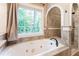 Elegant bathroom showcasing a luxurious tub with spa jets, elegant tile, and a separate shower area at 3851 Westwick Nw Way, Kennesaw, GA 30152