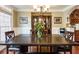 Formal dining room featuring wainscotting, a decorative china cabinet, decorative lighting, and large windows for ample natural light at 3851 Westwick Nw Way, Kennesaw, GA 30152