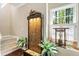 Hallway featuring a custom waterfall feature with ambient lighting, staircase, nearby windows, and an arrangement of indoor plants at 3851 Westwick Nw Way, Kennesaw, GA 30152