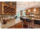 Open-concept kitchen featuring a wine rack, granite countertops, stainless steel appliances, and a breakfast bar with pendant lighting at 3851 Westwick Nw Way, Kennesaw, GA 30152
