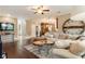 Open-concept living room with hardwood floors, a large sectional, and a view into the kitchen at 3851 Westwick Nw Way, Kennesaw, GA 30152