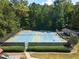 Aerial view of tennis courts surrounded by lush landscaping and shade at 3851 Westwick Nw Way, Kennesaw, GA 30152