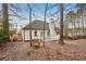 View of the home's backyard with a white deck and chimney, surrounded by trees at 4554 Alaspair Ln, Acworth, GA 30101