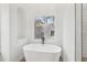 Close up of a modern white bathtub with black faucet and a window with a backyard view at 4554 Alaspair Ln, Acworth, GA 30101