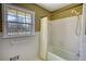 View of the bathtub and shower area of a bathroom with natural light coming in from the window at 5190 Paul Sw Cir, Conyers, GA 30094