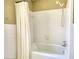 Close-up view of the bathtub, tile surround, shower curtain, and plumbing fixtures in the bathroom at 5190 Paul Sw Cir, Conyers, GA 30094