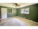 Spacious bedroom with neutral flooring, green walls, ceiling fan, and natural light at 5190 Paul Sw Cir, Conyers, GA 30094