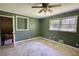 Bedroom featuring green walls, neutral floors, ceiling fan, and open doorway at 5190 Paul Sw Cir, Conyers, GA 30094