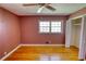 A bedroom featuring hardwood flooring, a ceiling fan, closet, and a window for natural light at 5190 Paul Sw Cir, Conyers, GA 30094