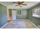 Bedroom featuring green walls, neutral floors, ceiling fan, and stairway access at 5190 Paul Sw Cir, Conyers, GA 30094