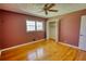 A bedroom featuring hardwood flooring, a ceiling fan, closet, and a window for natural light at 5190 Paul Sw Cir, Conyers, GA 30094