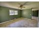 Bedroom with neutral flooring, green walls, ceiling fan, and window for natural light at 5190 Paul Sw Cir, Conyers, GA 30094
