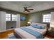 Bedroom with two windows, green walls, wood floor, and ceiling fan at 5190 Paul Sw Cir, Conyers, GA 30094