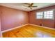 A bedroom showcasing the hardwood flooring, a ceiling fan, and window providing ample natural light at 5190 Paul Sw Cir, Conyers, GA 30094