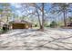 Large driveway with detached garage and mature trees, offering ample parking space at 5190 Paul Sw Cir, Conyers, GA 30094