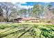 A brick ranch home with large lawn and mature trees on a sunny day at 5190 Paul Sw Cir, Conyers, GA 30094