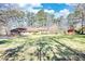 Brick ranch home with large lawn and a red barn-style outbuilding on a sunny day at 5190 Paul Sw Cir, Conyers, GA 30094
