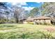 Brick ranch home with large lawn, mature trees, and a sunny sky at 5190 Paul Sw Cir, Conyers, GA 30094