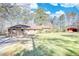Ranch home with brick exterior, large lawn, and red barn-style outbuilding at 5190 Paul Sw Cir, Conyers, GA 30094