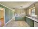 Open kitchen with green walls, two-tone cabinets, modern appliances, and tile flooring at 5190 Paul Sw Cir, Conyers, GA 30094