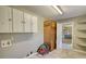 Laundry room with updated floors, storage cabinet, washer hookups, and access to other rooms at 5190 Paul Sw Cir, Conyers, GA 30094