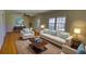 Living room with hardwood floors, neutral furniture, and large windows at 5190 Paul Sw Cir, Conyers, GA 30094
