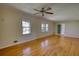 Open living room with hardwood floors, a ceiling fan, and large windows at 5190 Paul Sw Cir, Conyers, GA 30094