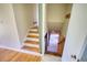 Stairway featuring wood steps, white risers, and view into basement at 5190 Paul Sw Cir, Conyers, GA 30094