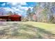 Exterior side yard of shed, home in the distance, and lush lawn at 5190 Paul Sw Cir, Conyers, GA 30094