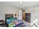 Bedroom with neutral walls, gray carpet, rustic wood furniture and closet door open to another room at 928 Gate Post Ln, Lawrenceville, GA 30044