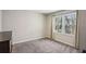 This is a bright bedroom featuring a large window with curtains and a dresser in the corner at 928 Gate Post Ln, Lawrenceville, GA 30044