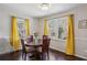 Cozy dining area features hardwood floors, natural light and yellow accent curtains at 928 Gate Post Ln, Lawrenceville, GA 30044