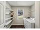 Well-lit laundry room featuring open shelving, natural light and modern washer and dryer at 928 Gate Post Ln, Lawrenceville, GA 30044