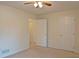 Neutral carpeted bedroom features ceiling fan and two doors at 732 Jacoby Dr, Loganville, GA 30052