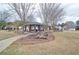 Inviting community area featuring a brick pavilion with seating and picnic tables, surrounded by a lush green space and mature trees at 732 Jacoby Dr, Loganville, GA 30052
