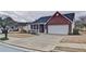 A charming brick home with a covered porch, well-maintained lawn, and a driveway leading to an attached two-car garage at 732 Jacoby Dr, Loganville, GA 30052