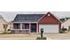 Charming brick home with a covered porch, well-maintained lawn, and an attached two-car garage at 732 Jacoby Dr, Loganville, GA 30052