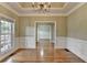 Charming dining room with hardwood floors, chandelier, large window, and detailed wainscoting at 3426 Olivia Grace Way, Dacula, GA 30019