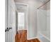 White bathroom featuring a tub and shower combination with wood-look flooring at 4970 Wewatta Sw St, Atlanta, GA 30331