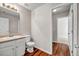 Bright bathroom featuring a single sink vanity, toilet, and wood-look flooring at 4970 Wewatta Sw St, Atlanta, GA 30331