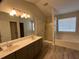 Bathroom featuring double sinks with hard surface countertops and separate tub with shower at 7925 Timberline Overlook, Cumming, GA 30041