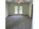 Spacious living room featuring carpet, ceiling fan, and French doors to a patio at 7925 Timberline Overlook, Cumming, GA 30041