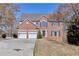 Charming two-story brick home with a two-car garage and a well-manicured front lawn on a sunny day at 1484 Highland Bluff Ct, Suwanee, GA 30024