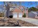 Charming two-story brick home with a two-car garage and a well-manicured front lawn at 1484 Highland Bluff Ct, Suwanee, GA 30024