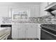 Bright kitchen features modern appliances, mosaic backsplash and window view at 1484 Highland Bluff Ct, Suwanee, GA 30024