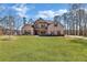 Two-story brick home featuring a well-manicured front lawn, blue sky, and mature trees at 180 Allie Dr, Mcdonough, GA 30252