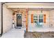 Charming front porch featuring brick, stone accents, and a cozy seating area at 180 Allie Dr, Mcdonough, GA 30252
