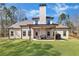 Backyard featuring covered porch with seating, manicured lawn, and wooded border at 180 Allie Dr, Mcdonough, GA 30252