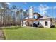 Backyard view featuring a covered porch and spacious lawn with wooded surround at 180 Allie Dr, Mcdonough, GA 30252
