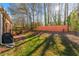 Scenic backyard featuring a lush lawn, mature trees, and a cozy patio area at 230 Rosenwald Ln, Hampton, GA 30228